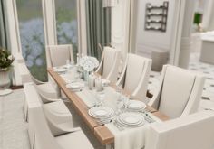 a dining room table with white chairs and place settings