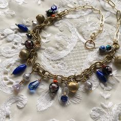 Stunning charm necklace made with vintage chunky chain with gold tone spheres, antique Chinese cloisonné enamel beads from circa 1940s, aurora borealis iridescent crystal glass, peacock toned carnival glass, vintage blue art glass, Czech glass, fire agate, a lucky eye charm and 1950s plastic pearls.  24kt gold plated chain at the back 24kt gold plated toggle clasp. Necklace is approx 18 inches in length.  Perfect for layering with other necklaces or as a statement piece. Each piece comes securel Handmade Vintage Dangle Chain Necklace, Gold-tone Brass Necklaces With Vintage Charm, Vintage Metal Beaded Chain Jewelry, Vintage Charm Gold-tone Brass Necklace, Vintage Brass Beaded Necklace With Round Beads, Gold Beaded Pendant Necklace With Charms, Vintage Gold Jewelry With Beaded Chain, Gold Beaded Necklace With Charms And Pendant, Eclectic Gold Jewelry Gift