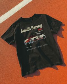 Step into the racing history of Sicily with our Amalfi Racing 1973 Tee. Inspired by the Targa Florio, this tee brings the excitement of coastal speed and vintage elegance to your wardrobe. Unisex soft cotton crew neck t-shirt featuring a Amalfi Racing Vintage Car graphic printed on the front. Fabrics: 100% cotton, 6 oz Made in: LA Car Tshirt Design Graphic Tees, Car Shirt Design, Car Tshirt Design, Car T Shirt Design, 90s Shirts Graphic Tees, Vintage Car Shirt, Vintage Car Graphic, Mens Clothing Styles Streetwear, Car Graphic Tee