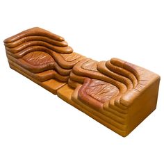 an inflatable couch made out of wood and leather, with curved cushions on the back