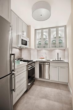 a kitchen with stainless steel appliances and white cabinets