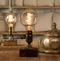 three light bulbs sitting on top of a wooden table