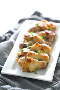 grilled chicken on a white plate with garnishes