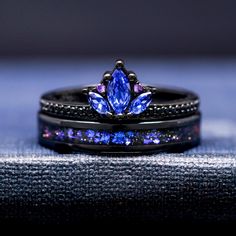 two wedding rings with blue and purple stones on top of each other's bands