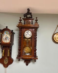 three wooden clocks are hanging on the wall