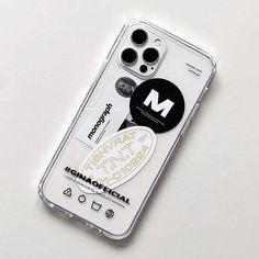 an iphone case with the letter m on it and some stickers attached to it