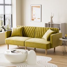 a living room with a green couch and white rugs on the wooden flooring