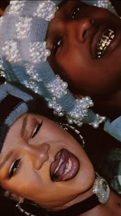 two women are posing for the camera with pearls on their head and one woman has her eyes closed