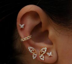 a woman's ear with three different types of piercings