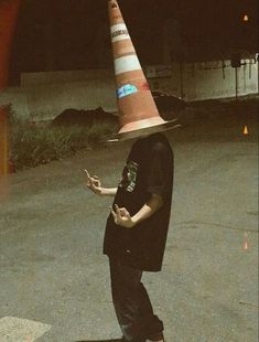 a man wearing a traffic cone hat on top of his head