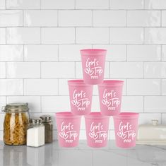 six pink cups sitting on top of a counter