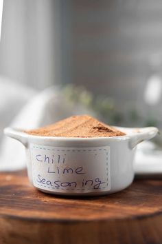 a bowl filled with chili seasoning sitting on top of a wooden table