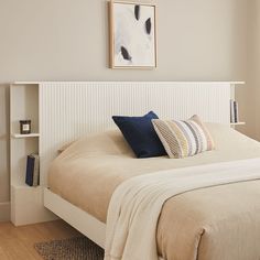 a bedroom with a bed, bookcases and pictures on the wall above it