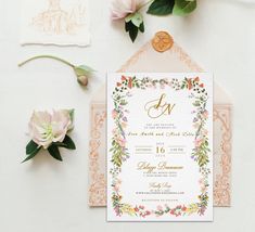 the wedding stationery is displayed with flowers and greenery