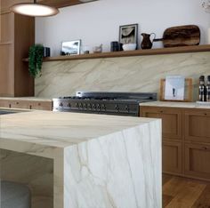 a kitchen with wooden cabinets and white marble counter tops, along with an island in the middle