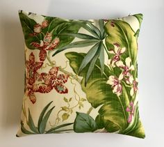 a green and red floral pillow on a white wall