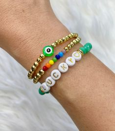 Gold Evil Eye Bracelet With Letter And Round Beads, Gold Beaded Evil Eye Bracelet For Friendship, Gold And Heishi Beads Stretch Bracelet Gift, Gift Stretch Bracelet With Gold And Heishi Beads, White Round Beaded Bracelet For Good Luck, Evil Eye Bracelet With Letter Beads As Gift, Gold Heishi Beads Bracelets With 8mm Beads, Green Beaded Bracelets For Good Luck, Gold Beaded Bracelets For Friendship