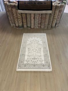 a rug is on the floor in front of a bookcase with many books behind it