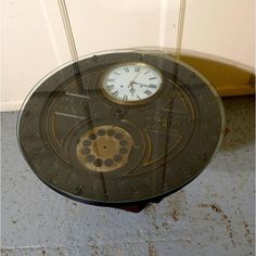 a clock sitting on top of a glass table