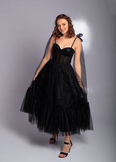 Step into elegance with this stunning black corset midi tulle dress, perfect for proms, parties, weddings, and formal events. This exquisite evening dress features a fitted corset bodice adorned with shimmering sequins, creating a glamorous and sophisticated look. The flowing tulle skirt adds a touch of whimsy and movement, making you feel like a true princess. The midi length offers a modern twist on classic elegance, while the delicate straps and bow detailing add a playful touch. Crafted from Tulle Evening Dress For Prom Season, Tulle Evening Dress For Prom, Black Corset Dress With Sheer Bodice For Prom, Glamorous Tulle Corset Dress With Fitted Bodice, Black Corset Dress For Prom Evening, Glamorous Overbust Prom Dress, Glamorous Corset Dress With Corset Back For Debutante Ball, Prom Season Organza Corset Ball Gown Dress, Overbust Evening Dress For Prom Season