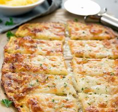 a pizza with cheese and herbs cut into squares