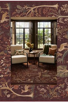 a living room with two chairs and a table in front of a window that has birds on it