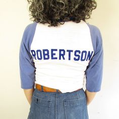 Details: Vintage 70s Distressed Gulf Shore Sportswear Baseball Tee Dingy White and faded blue raglan (colors are duller in person than photos) Iron on velvet letters on back " Robertson " longer in middle front and back then sides serge swam hem that rolls Single Stitch  Crew neck *collar is a brighter blue and different material than rest of tee Distressed-has pilling, lots of spots/stains, fading, holes Brand: Gulf Coast Sportswear  Material: Cotton/Poly  Size: XS/S  Measurements Approx: taken flat then doubled if needed Shoulders: 13" Chest: 30"-34" Sleeve: 13" Waist: 29" Length: 26" collar to front hem/ 22" shoulder to side hem Condition: Good Vintage- distressed wear-some fading, holes, pilling, pulls, spots/stains, etc. *Colors of items may differ slightly from photos due to camera, Dingy Whites, Raglan Sleeve Shirt, Gulf Coast, Neck Collar, True Vintage, Baseball Tee, Raglan Sleeve, Vintage 70s, 1970s