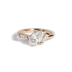 a pear shaped diamond engagement ring in yellow gold