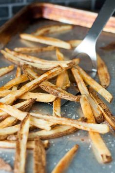 french fries on a tray with a spatula in the middle, ready to be eaten