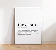 a black and white poster that says the cabin on it's side in an empty room