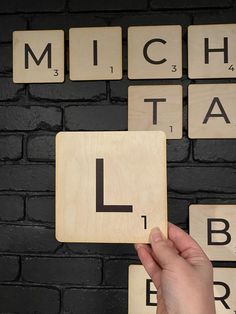 scrabble tiles with the letters l and i in front of a brick wall