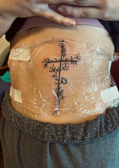 a person with a cross tattoo on their stomach is taped to the side by tape