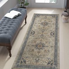 a blue bench sitting in front of a window next to a rug on the floor