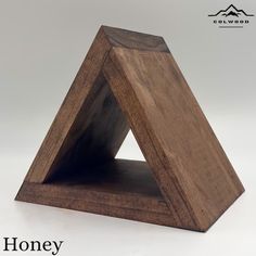 a wooden triangle shaped object with the words honey on it's front and bottom