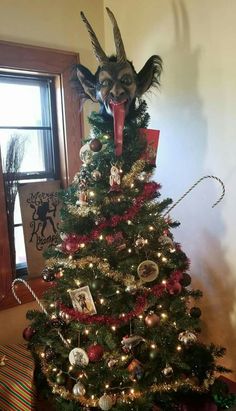 a cat is sitting on top of a christmas tree