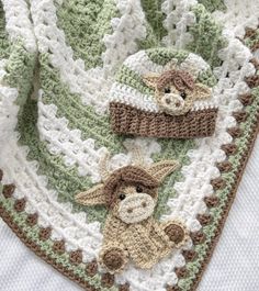 there is a crocheted blanket with two stuffed animals on it