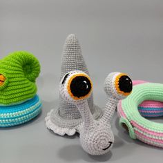 three crocheted toys are sitting next to each other