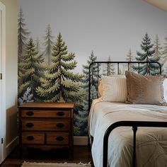 a bedroom with a bed, dresser and wallpaper that has trees painted on it