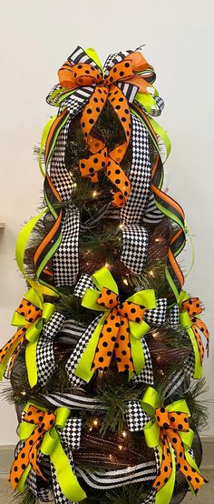 a decorated christmas tree with orange and black bows