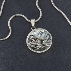 Introducing our exquisite Circle Pendant Necklace, showcasing the breathtaking elegance of a snow leopard as it gracefully navigates the rugged, icy terrain of a majestic mountain range. This intricate design captures the essence of the elusive snow leopard, blending the stark beauty of its natural habitat with the refined artistry of a stained glass style. Forged from premium surgical steel and available with a lavish 18k gold finish, this innovative jewelry boasts our exclusive design, handcrafted with care right here in the U.S.A by our dedicated team of skilled working mothers. When you choose our necklace, you not only acquire a stunning memento for yourself or a cherished one but also champion the empowerment of working mothers and vibrant communities. Rest assured, your satisfaction Circle Pendant Necklace, Luxury Necklace, Glass Style, Working Mother, Snow Leopard, Mountain Range, Working Moms, Circle Pendant, Intricate Design