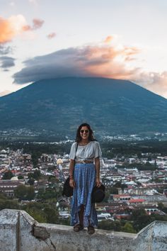 a woman standing on top of a stone wall