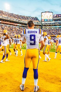 a group of football players standing on top of a field