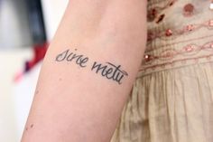 a woman with a tattoo on her arm that reads, since weltu in cursive writing