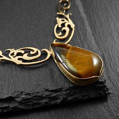 ► Unique gold-plated pendant with a teardrop-shaped Tiger's Eye semi-precious stone (28X16mm)! A Celtic design artfully holds a unique semi-precious stone, creating a piece of art for a unique woman... Decorate your neck with unique jewelry that ONLY you will wear.... Accompanied by a gold-plated chain! Behind him is a magical bat! 100% Handmade L&M creation! ☼ All eyes have been known since ancient times as talismans for health, since in their own way they warned their owner in time of any upco Yellow Gold Cabochon Teardrop Pendant Necklace, Gold Cabochon Pendant Necklace, Luxury Teardrop Cabochon Jewelry, Gold Pendant Necklace With Cabochon, Artisan Yellow Gold Teardrop Jewelry, Formal Teardrop Cabochon Necklace, Gold Cabochon Teardrop Pendant, Gold Cabochon Teardrop Pendant Jewelry, Luxury Handmade Teardrop Necklaces