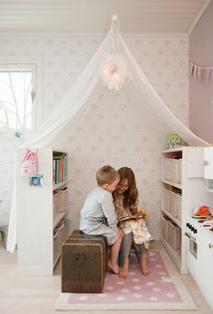 two children are sitting in a small room