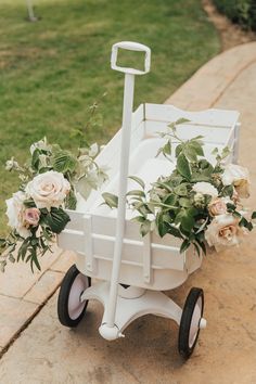 a white wagon filled with flowers and greenery