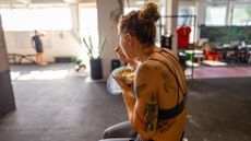 a woman sitting on top of a motorcycle eating food