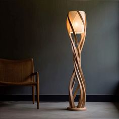 a lamp that is next to a chair in a room with a wall behind it