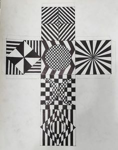 the cross is made up of black and white geometric designs, which appear to have been drawn on paper