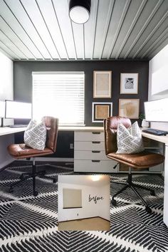 an office with two brown leather chairs in it